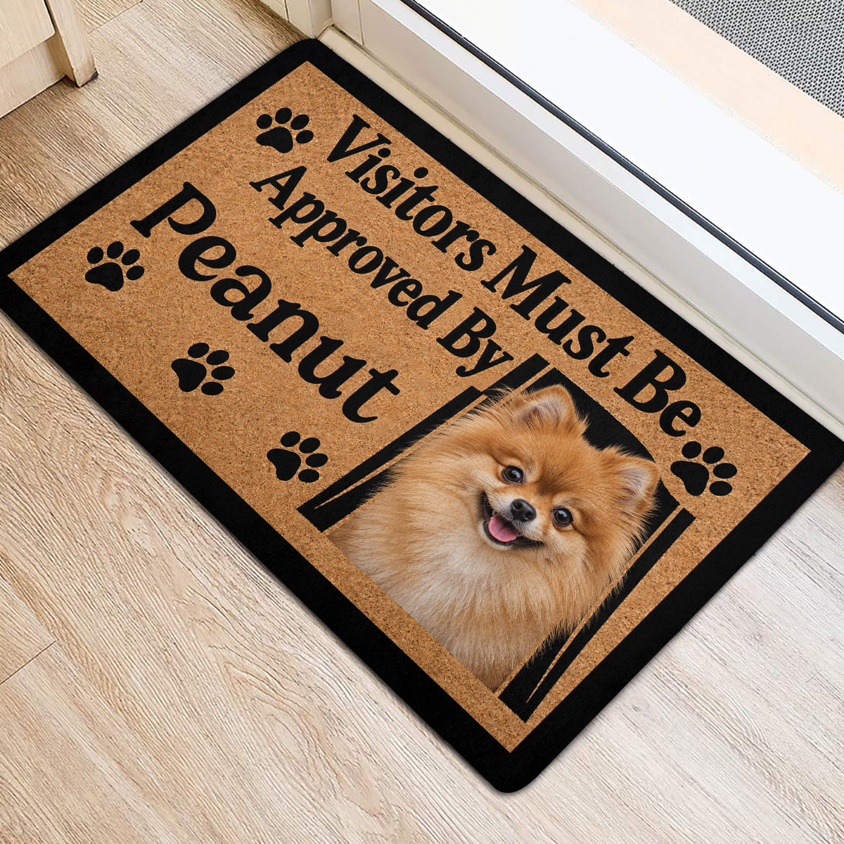 Pomeranian dog portrait doormat positioned at an indoor doorway with paw print accents
