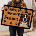Person holding a Saint Bernard doormat featuring paw prints and a welcoming dog portrait