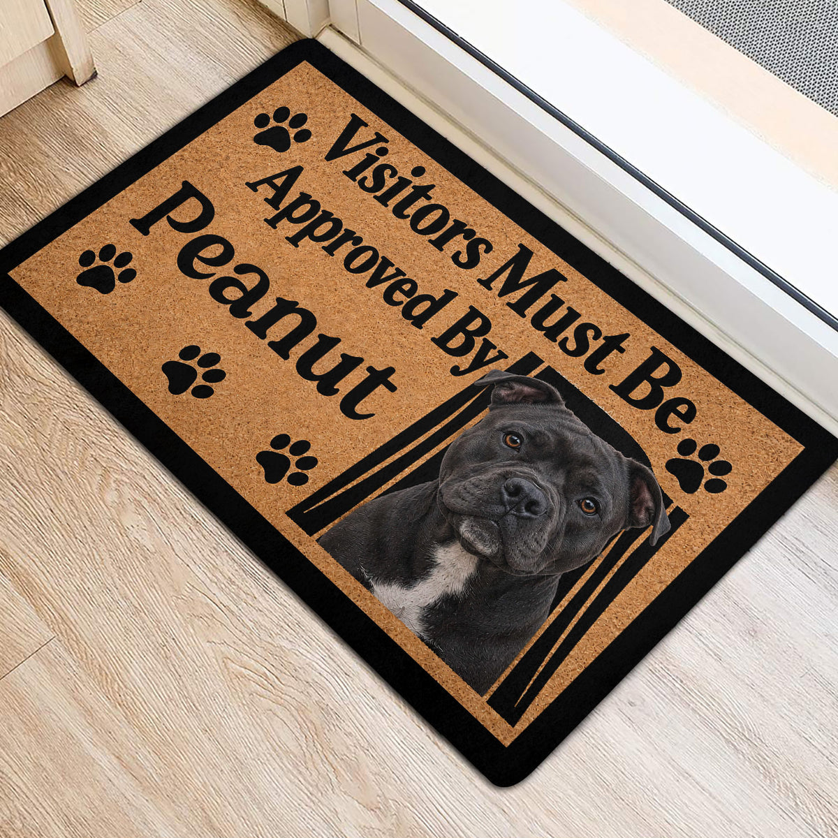 Staffordshire Bull Terrier entryway rug displayed beside a doorway with paw print artwork