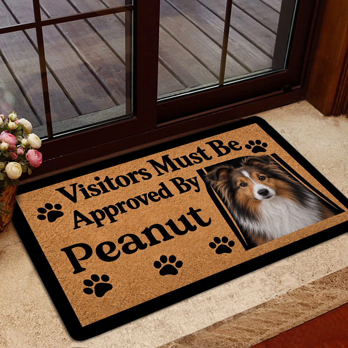 Sheltie welcome doormat styled inside a glass doorway with a wood deck visible outside