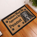 Greyhound doormat displayed in an indoor entryway beside a white door and wood flooring