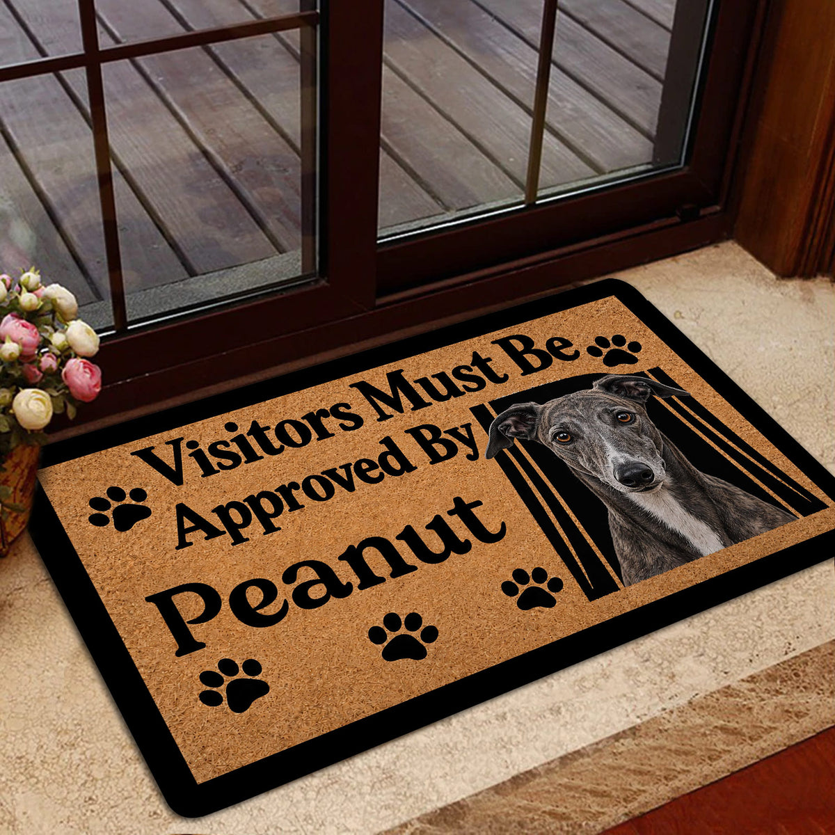 Greyhound doormat styled at a glass door with a warm tan design and black border