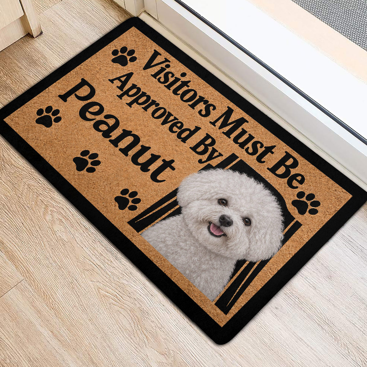 Bichon Frise front door mat featuring a smiling white dog portrait, paw prints, and black border