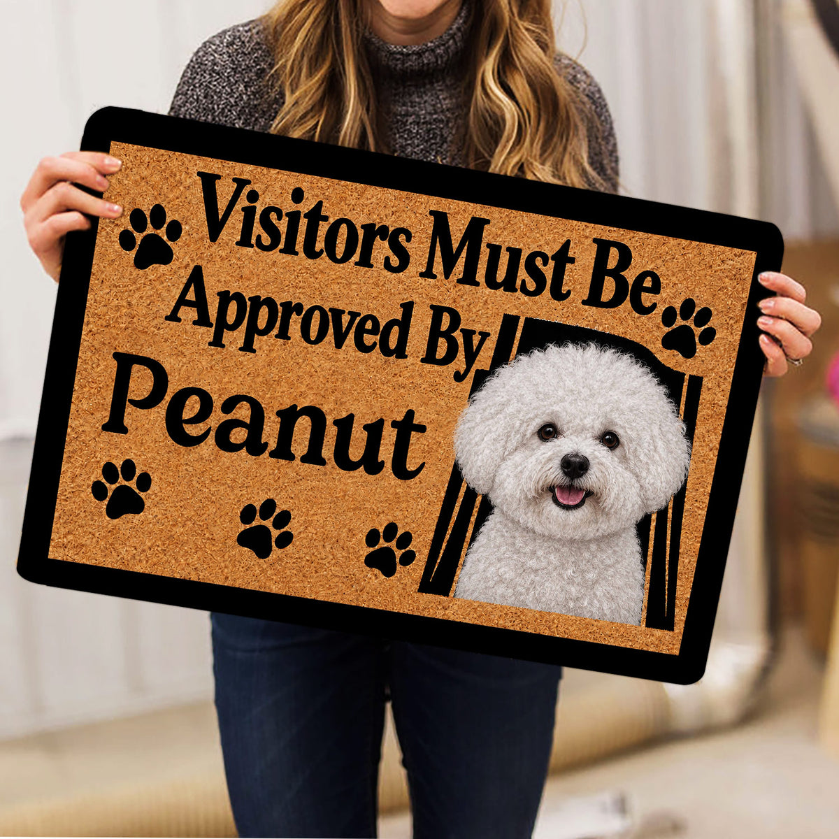 Person holding a Bichon Frise doormat featuring a cheerful white dog portrait and paw print artwork