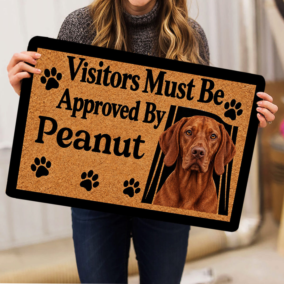 Vizsla dog doormat held indoors showing a realistic dog portrait, paw prints, and bold welcoming typography
