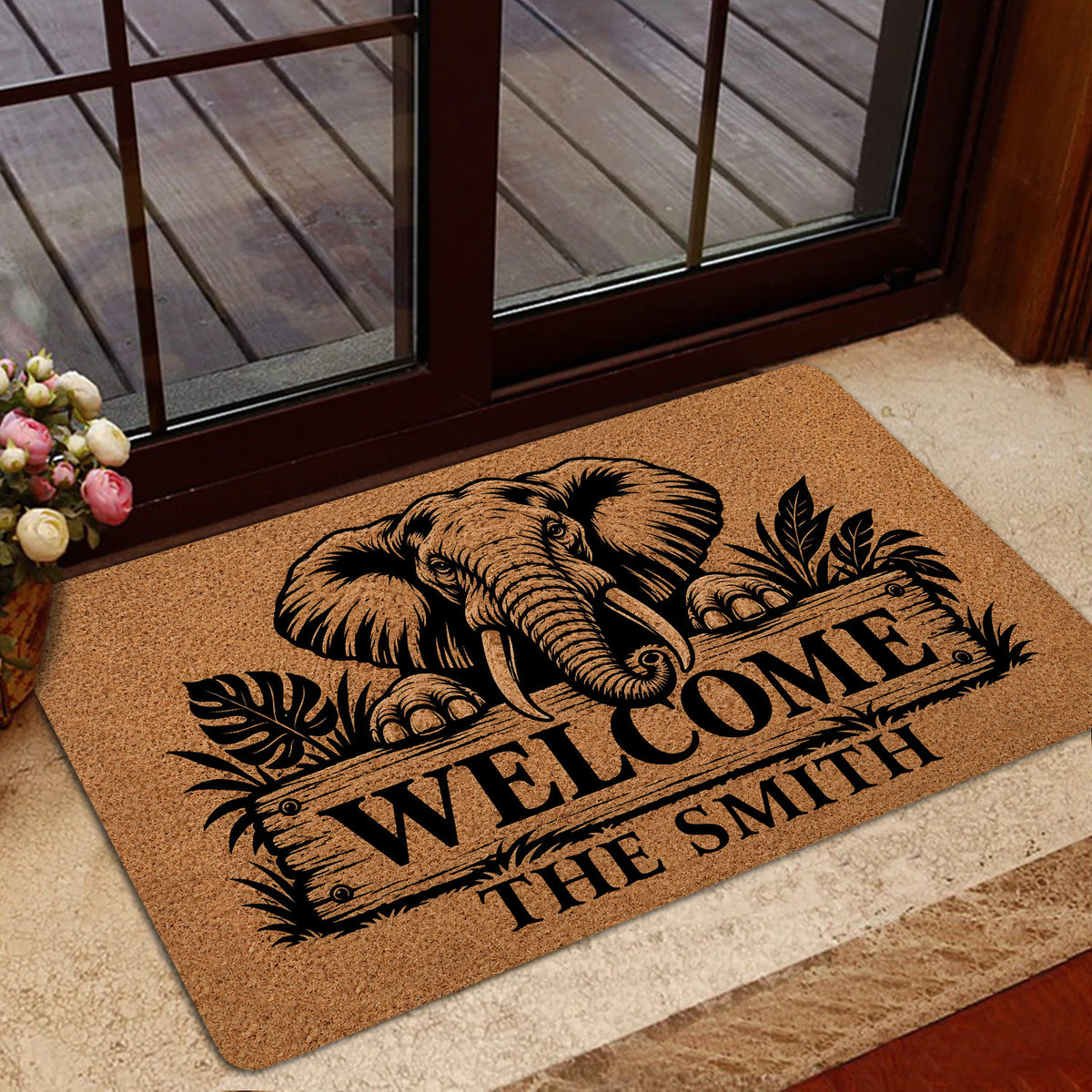 Elephant entryway mat positioned by glass doors with a bold black welcome design