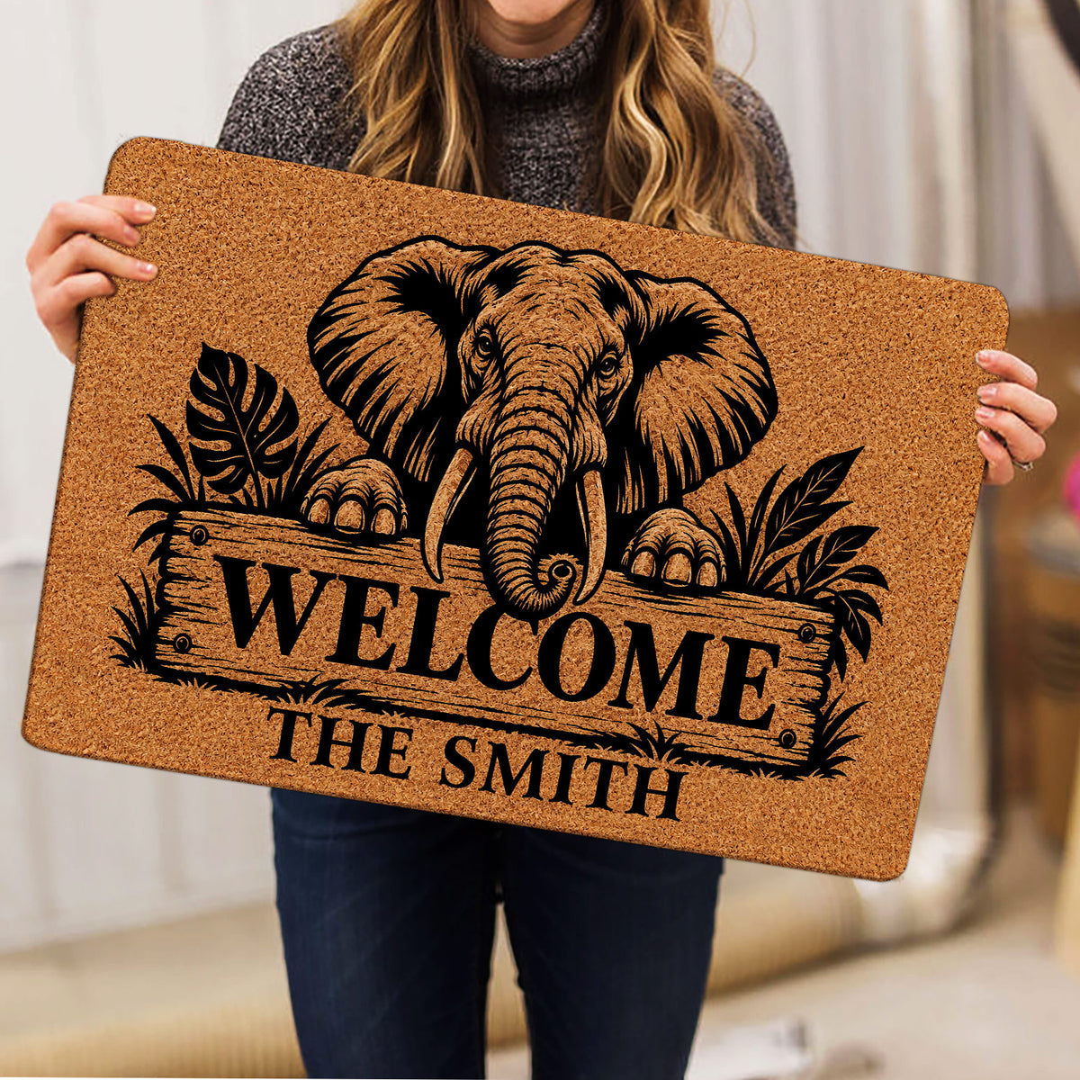 Elephant doormat held indoors, showing detailed wildlife artwork and a welcoming entryway design