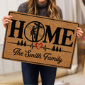 Person holding a lineman doormat featuring a utility worker, HOME lettering, trees and heart motif