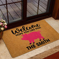 Pig-themed entryway doormat displayed beside a glass door with a warm home decor setting