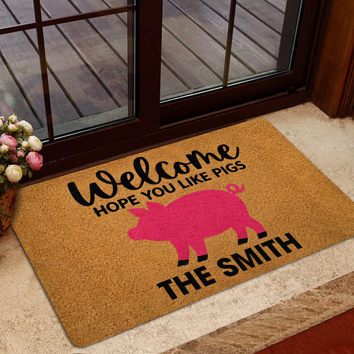 Pig-themed entryway doormat displayed beside a glass door with a warm home decor setting