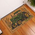 Green tractor entryway rug displayed beside a white door on a warm wood floor