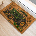 Tractor-themed front door mat with wheat and leafy accents shown on a light wood floor