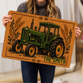 Person holding a tractor doormat featuring vintage farm artwork, wheat stalks, and earthy colors