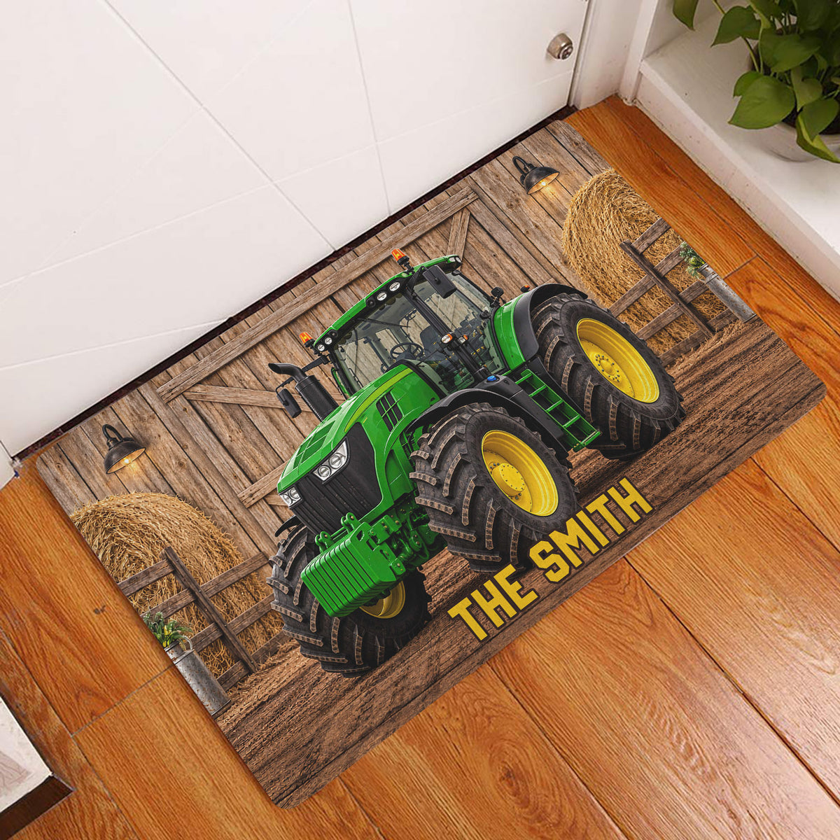 Green tractor doormat displayed on a warm wood floor near an interior doorway