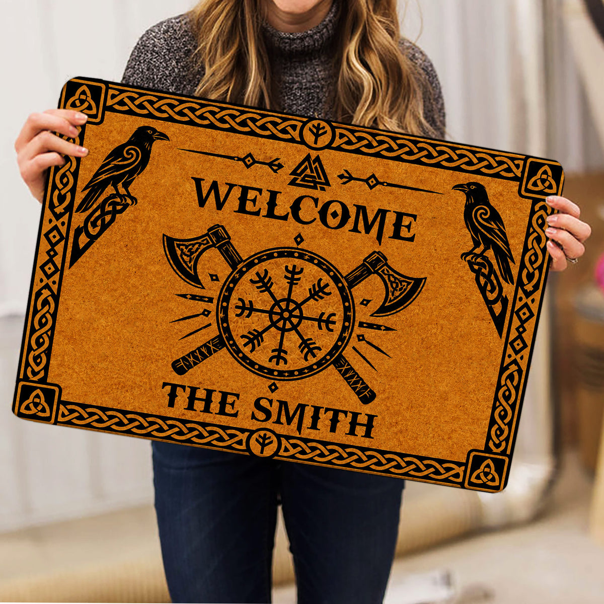 Viking doormat held indoors displaying ravens, axes, compass symbol, and black knotwork artwork