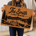 Lake house doormat held indoors showing rustic mountain lake scenery, pine trees, dock, and canoe