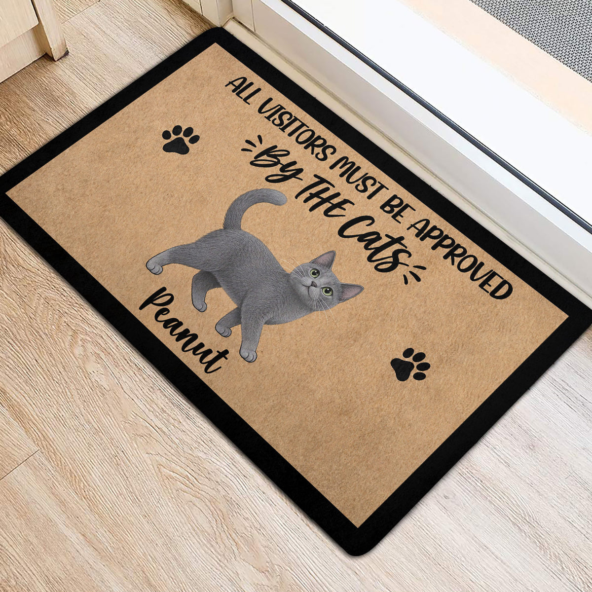 Gray cat entryway mat positioned near a doorway on light wood flooring