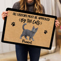 Person holding a gray cat doormat featuring paw prints and playful entryway artwork