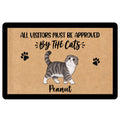 Scottish Fold cat doormat with paw prints and playful visitor approval artwork on a tan surface