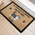 Cat-themed entryway mat positioned beside a doorway on a light wood floor