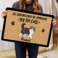 Person holding a cat-themed doormat featuring an Exotic Shorthair illustration