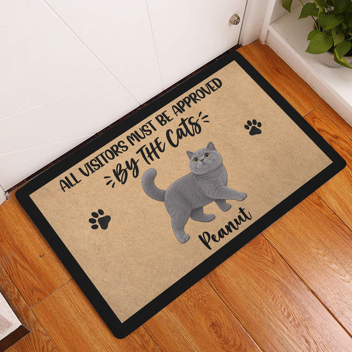 British Shorthair cat entryway mat displayed on a warm wood floor by a door