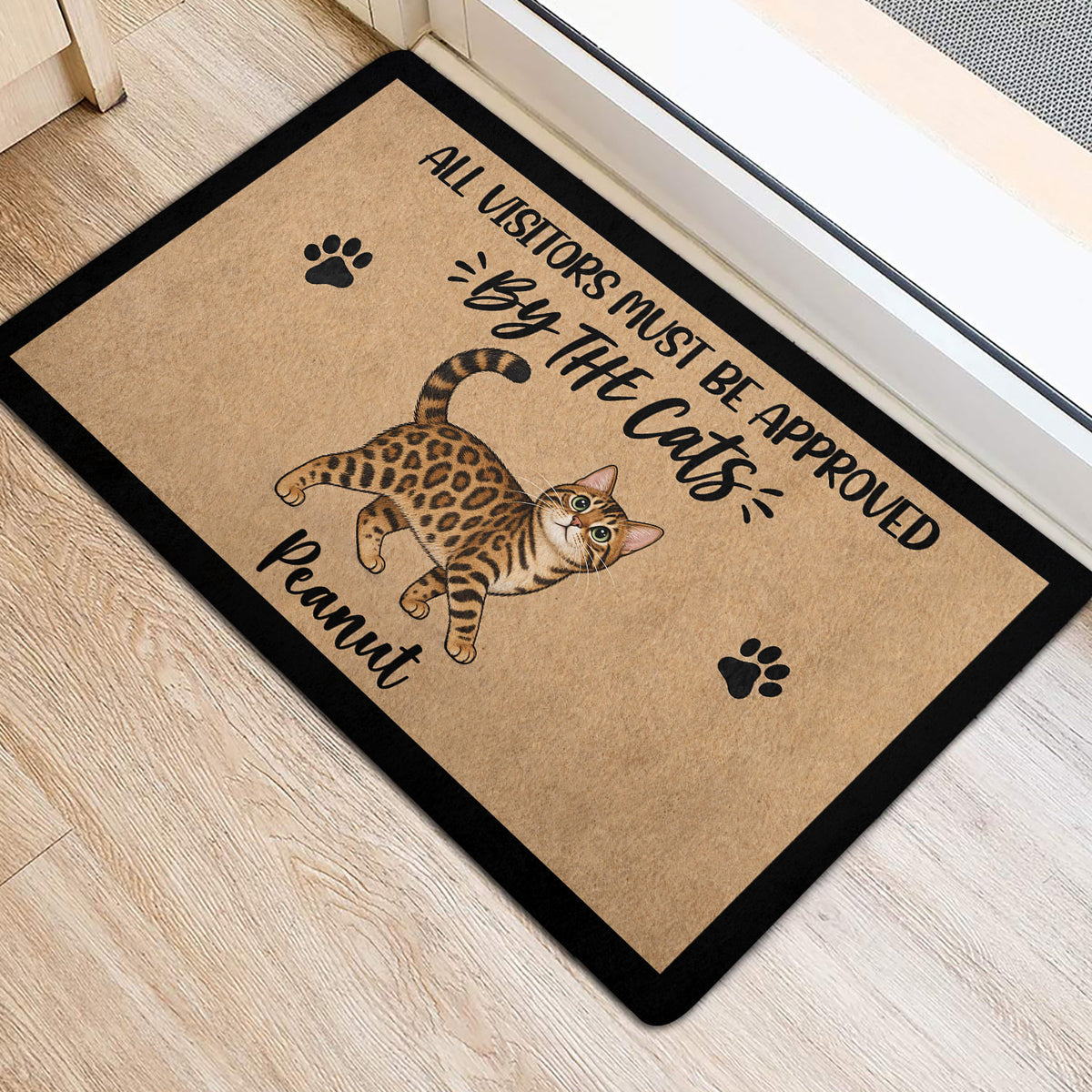 Bengal cat entryway mat positioned near a doorway on light wood flooring with paw print artwork