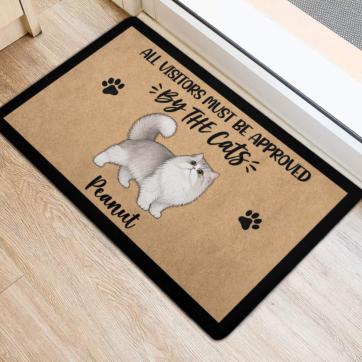 Persian cat entryway mat with playful lettering and paw prints beside a light wood floor