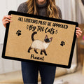 Person holding a Siamese cat doormat featuring playful artwork and paw prints