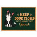 Tuxedo cat doormat with paw prints and playful escape-themed artwork on a dark green background