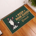 Tuxedo cat entryway rug displayed beside a white door on a warm wood floor
