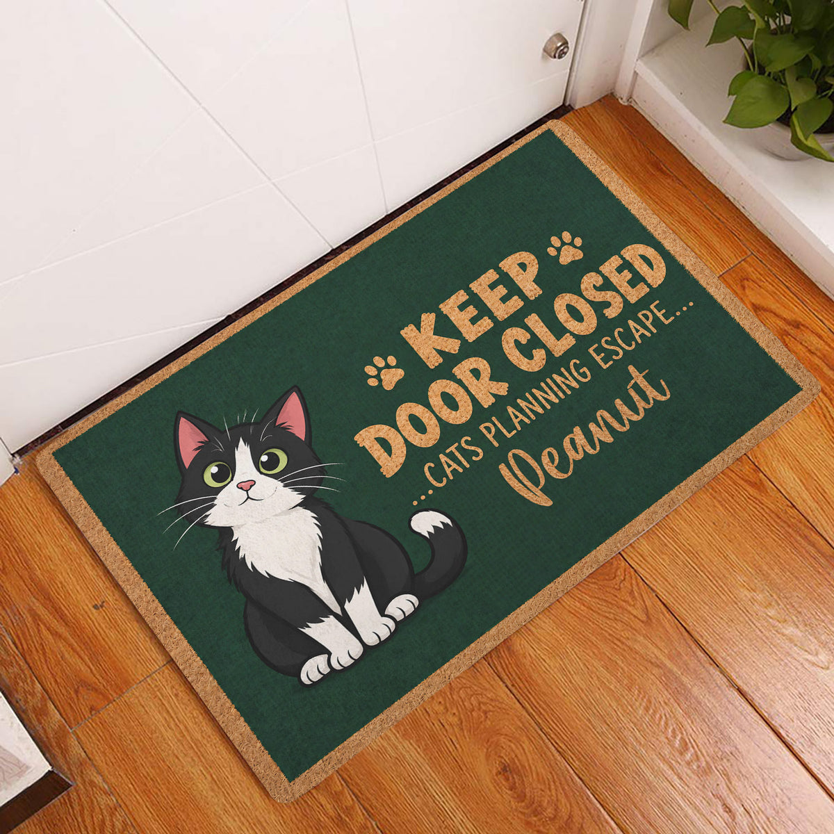 Tuxedo cat entryway rug displayed beside a white door on a warm wood floor