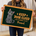 Person holding a Russian Blue cat doormat featuring a gray cat and paw print design