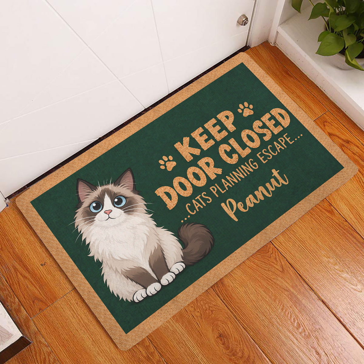Ragdoll cat doormat styled at an indoor doorway on a warm wood floor