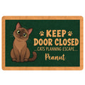 Funny Burmese cat doormat with cartoon brown cat, green panel, tan border, paw prints and keep door closed cats planning escape quote