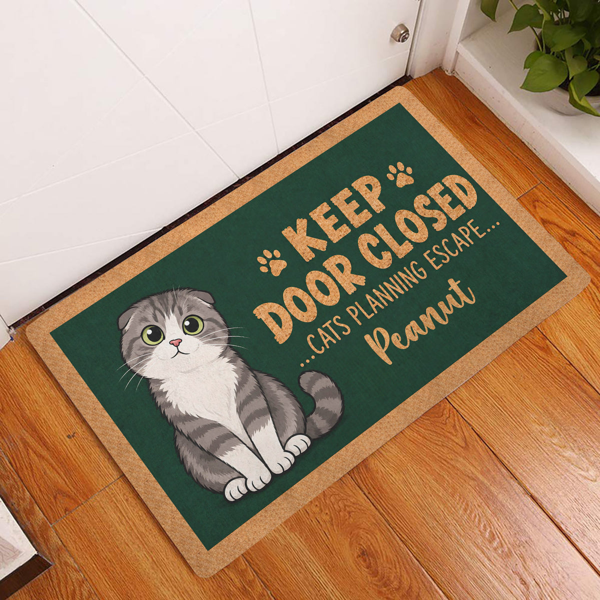 Scottish Fold cat entryway mat displayed beside a white door on a warm wood floor