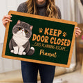 Person holding an Exotic Shorthair cat doormat featuring paw prints and playful entryway artwork