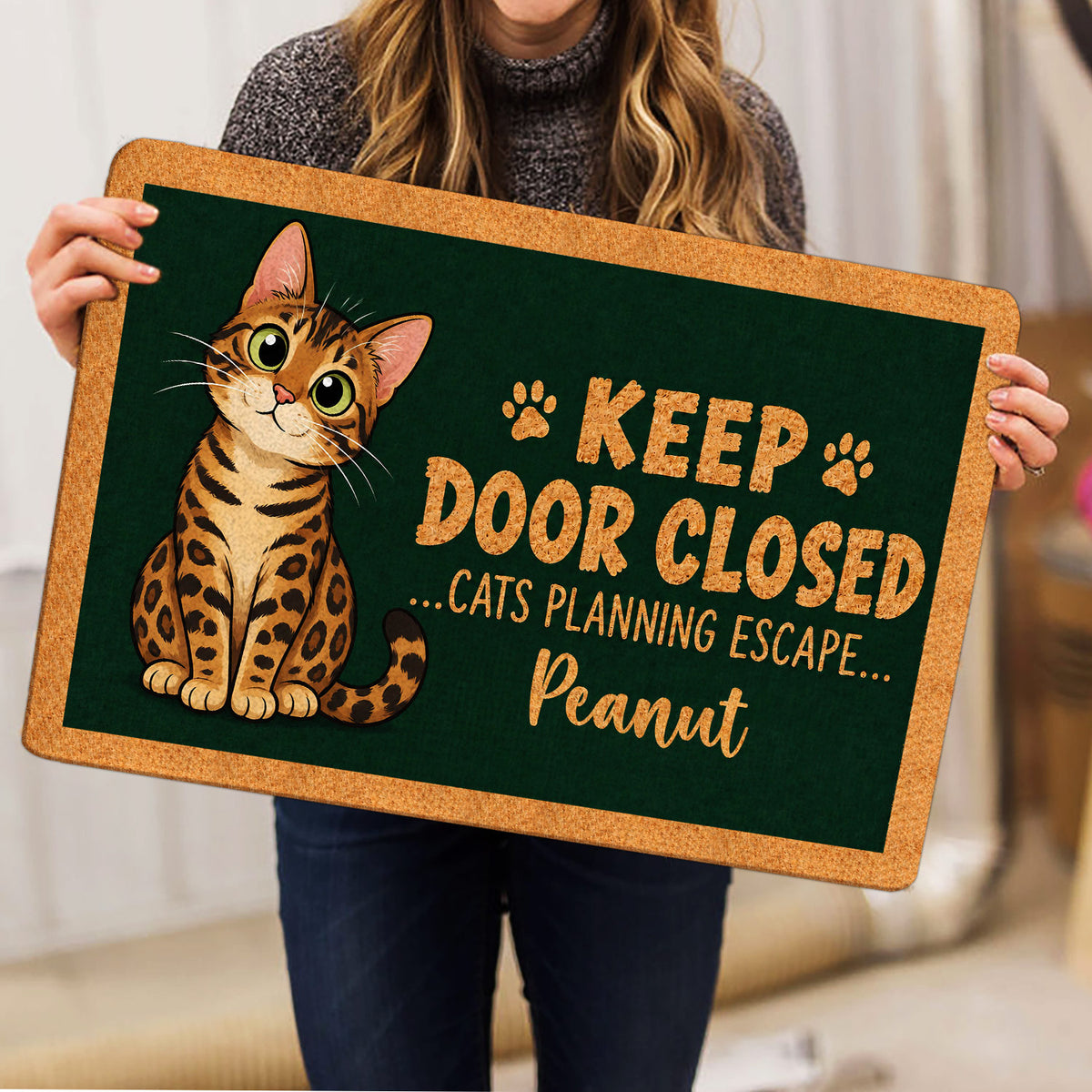 Bengal cat doormat held indoors, showing the spotted cat illustration and paw prints