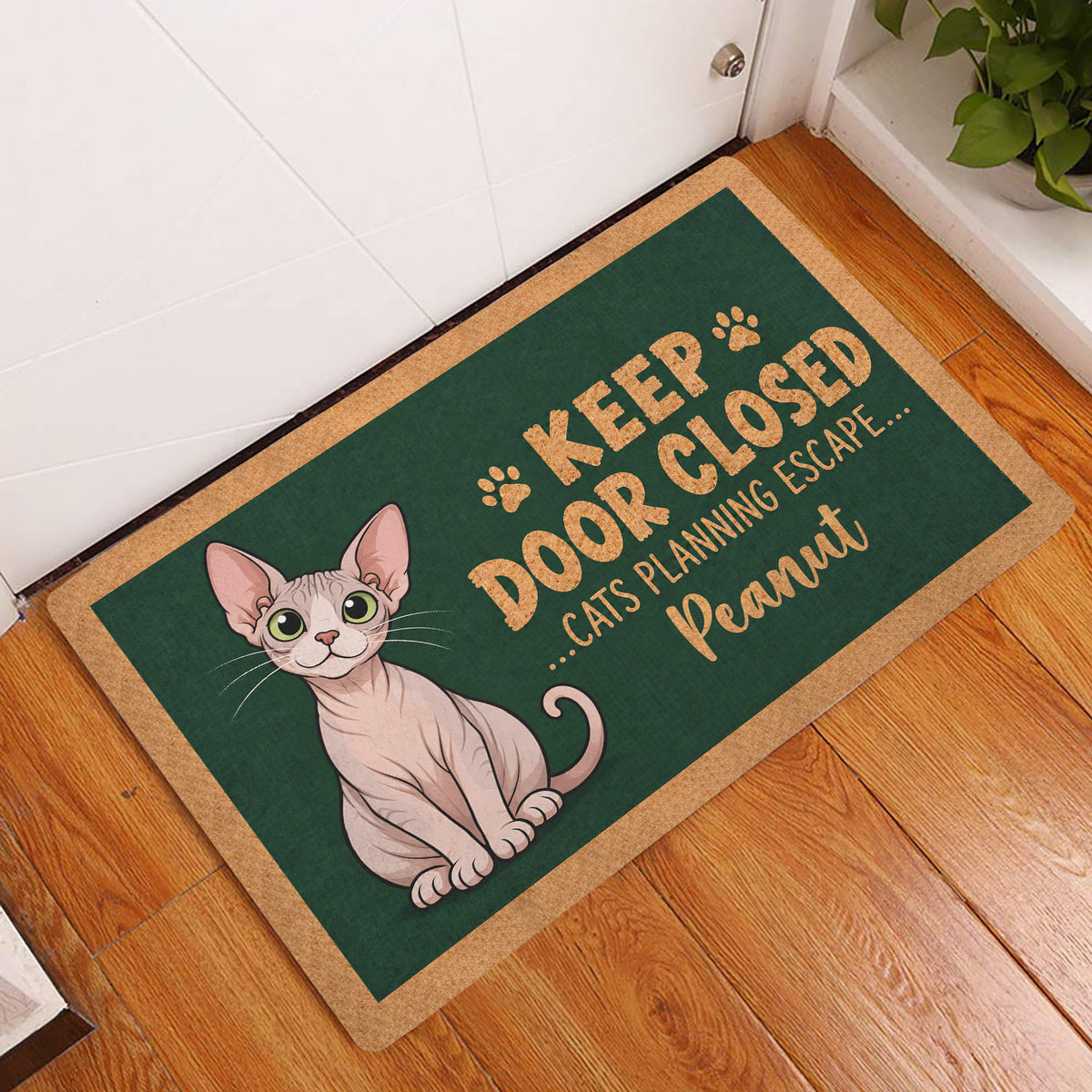 Sphynx cat entryway doormat displayed beside a white door on a warm wood floor