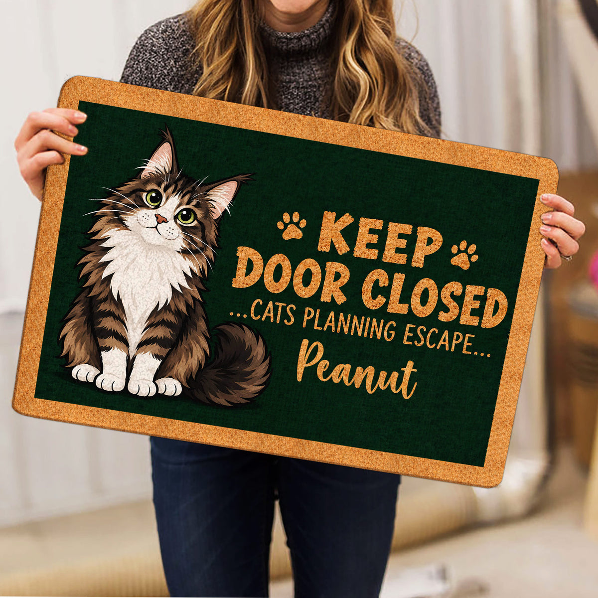 Maine Coon cat doormat held indoors, showing the full dark green design and tan border