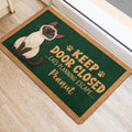 Siamese cat door mat shown near a bright doorway with green artwork and tan border