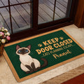 Siamese cat doormat styled inside a glass doorway with a humorous escape-themed design