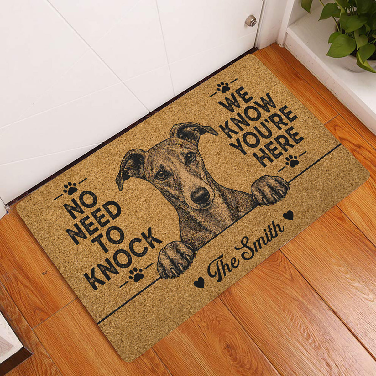 Whippet entryway rug displayed beside a white door on wood flooring with playful paw-print artwork