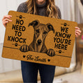 Person holding a tan Whippet doormat featuring a detailed dog portrait, paw prints, hearts, and bold lettering