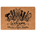 Tan hairstylist doormat with black hair tools, floral accents, welcome lettering, and salon-themed design