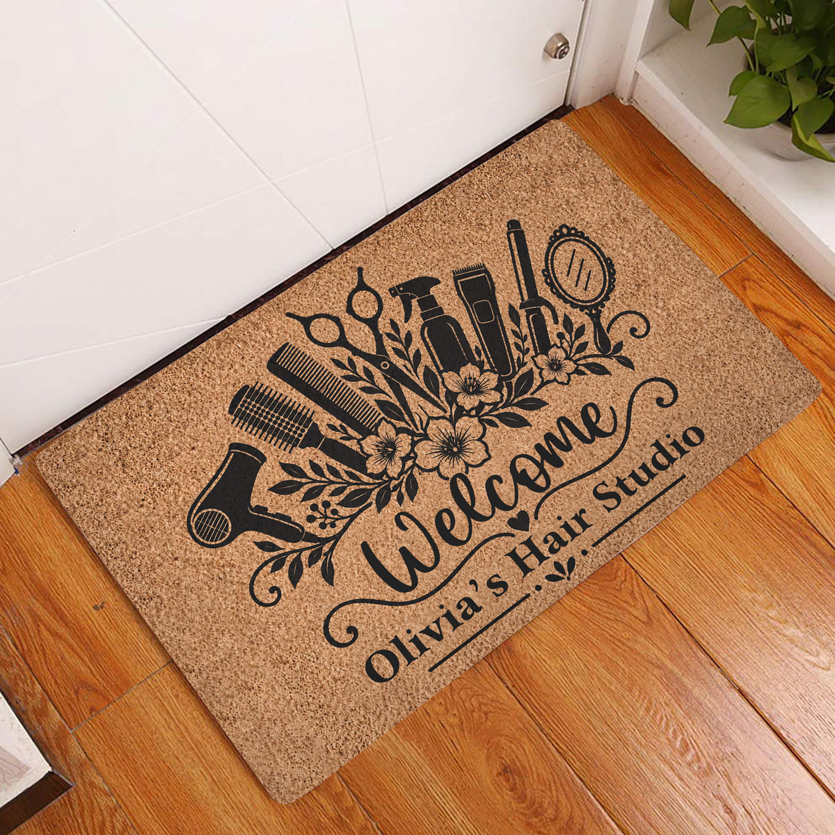 Hairstylist doormat displayed at an indoor doorway on a hardwood floor with salon tool artwork