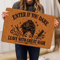 Person holding a hairstylist doormat featuring a woman’s hairstyle, scissors, comb and bold black artwork