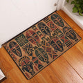 African mask pattern doormat displayed at a home entrance on a warm wood floor