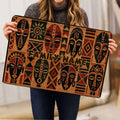 African mask design doormat shown in a home setting with bold earthy colors and geometric details