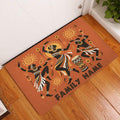 African dance doormat displayed in an indoor entryway on a wood floor beside a white door